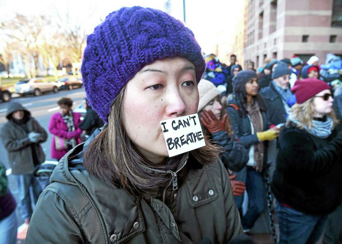 (Arnold Gold-New Haven Register) Emily Byrne (center) of New Haven listens to speakers at the Rally for Peace, Journey for Justice organized by the Greater New Haven NAACP, the Greater NAACP Youth Council and the Greater New Haven NAACP College Chapters in front of City Hall on 12/7/2014.