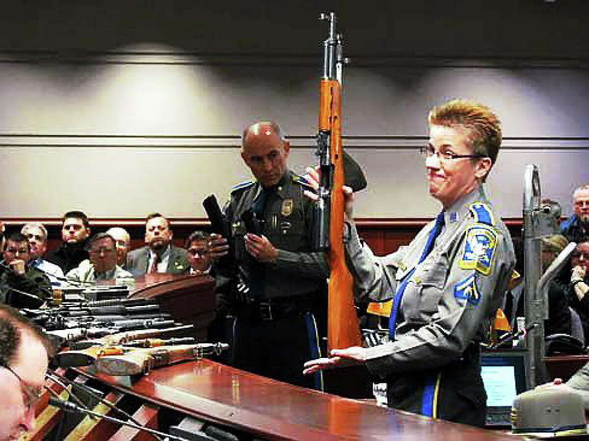 State Police Detective Barbara Mattson holds up a gun for lawmakers at a public hearing in January.