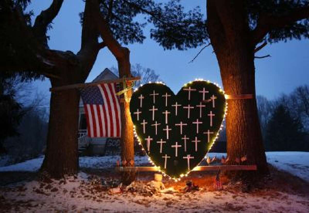 - In this Saturday, Dec. 14, 2013, file photo, a makeshift memorial with crosses for the victims of the Sandy Hook massacre stands outside a home in Newtown, Conn.,