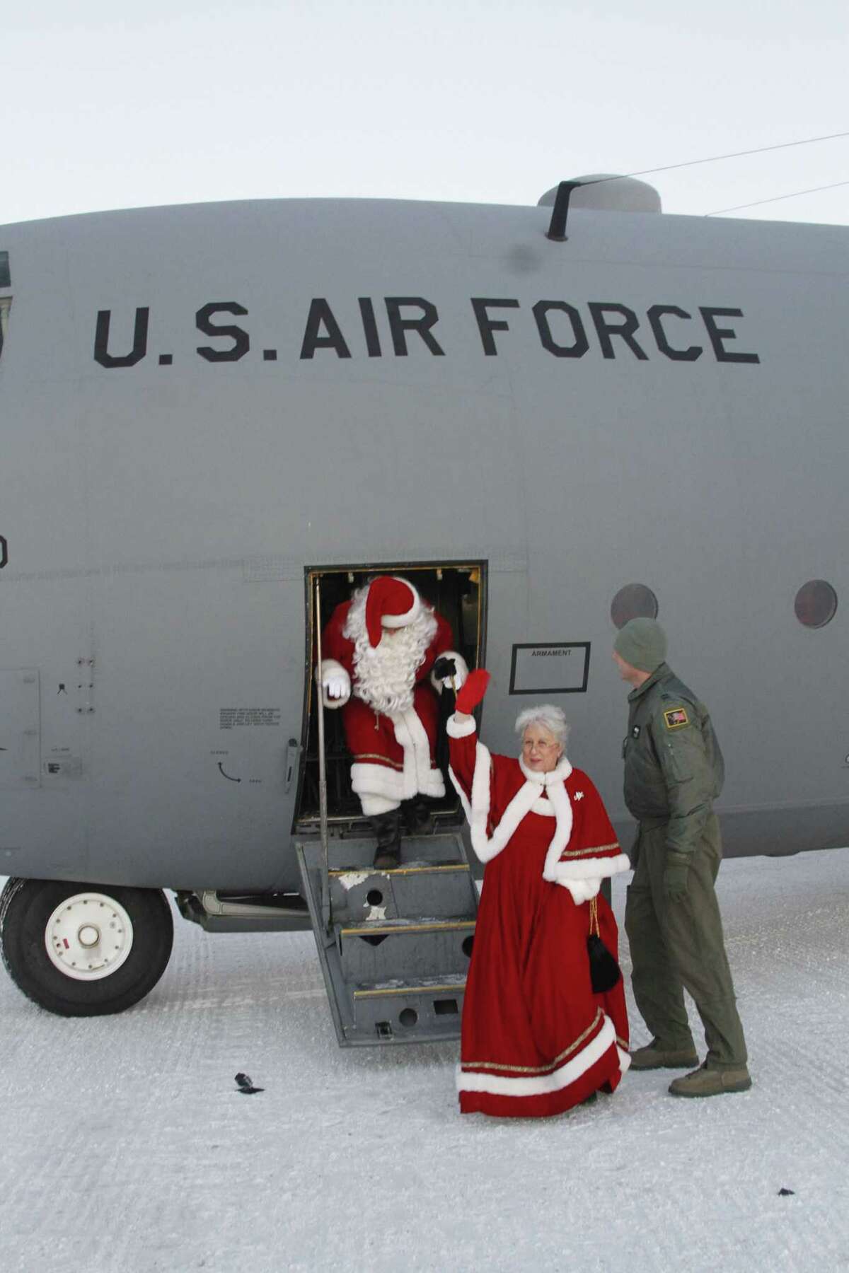 This photo taken Dec. 6, 2014, shows Santa and Mrs. Claus getting off a C130 military transport plane in Shishmaref, Alaska. The Alaska National Guard provided transport for the good Samaritan program Operation Santa, which took gifts and schools supplies to about 300 children in the Inupiat Eskimo community. (AP Photo/Mark Thiessen)