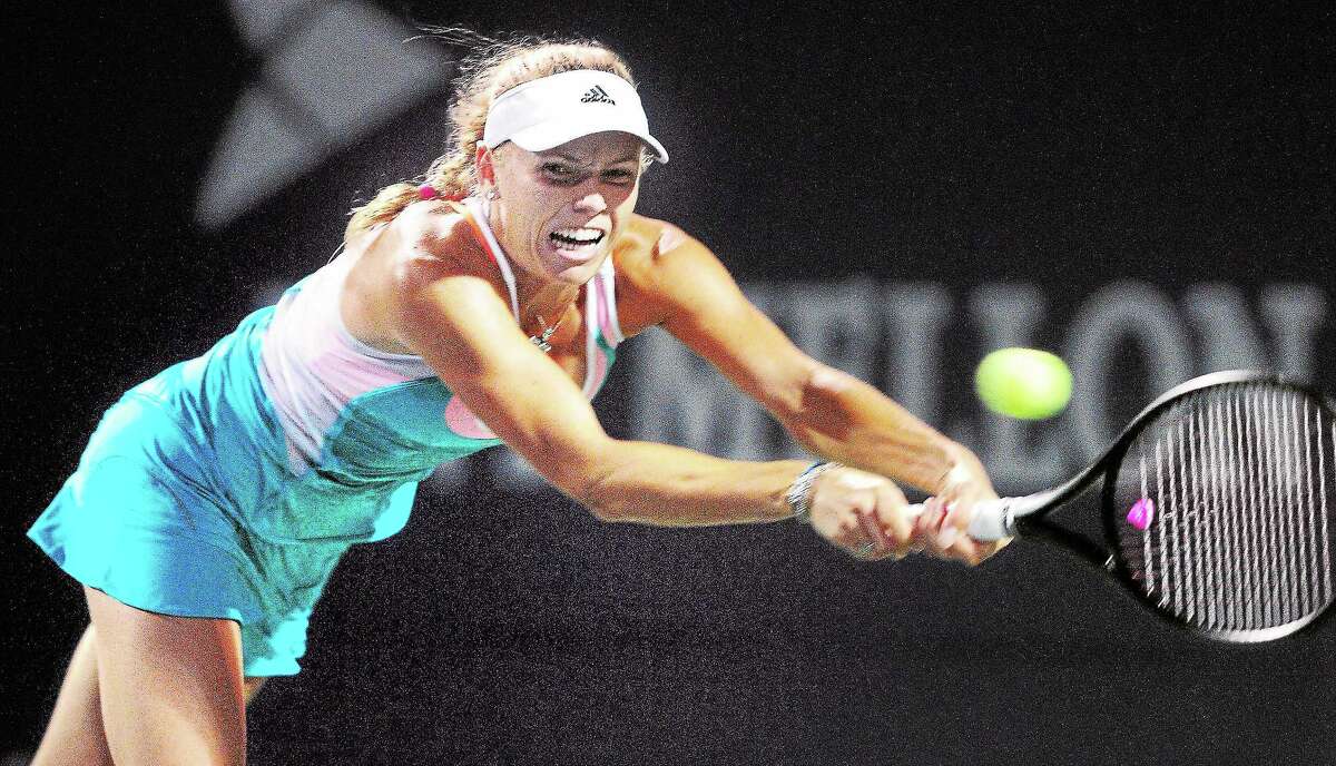 Caroline Wozniacki hits a backhand to Shuai Peng in a first-round match at the New Haven Open on Monday.