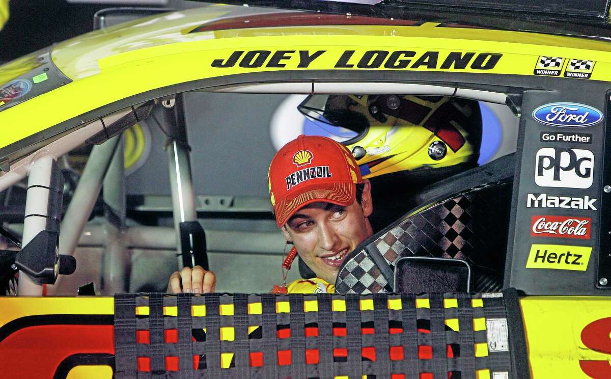 Driver Joey Logano peeks out his window as he pulls into victory lane after winning Saturday night in Bristol, Tenn.