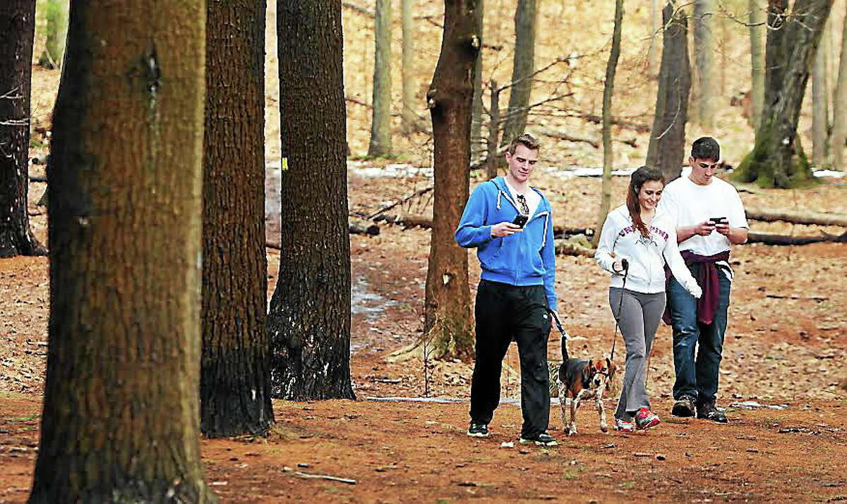 Billy Holt of Milford, 19, Ariell Muecko of Derby, 23, and John Longo of Yardsley, N.Y., left to right, stroll down from Sleeping Giant State Park’s Tower Trail in Hamden Thursday, taking advantage of the springtime weather.
