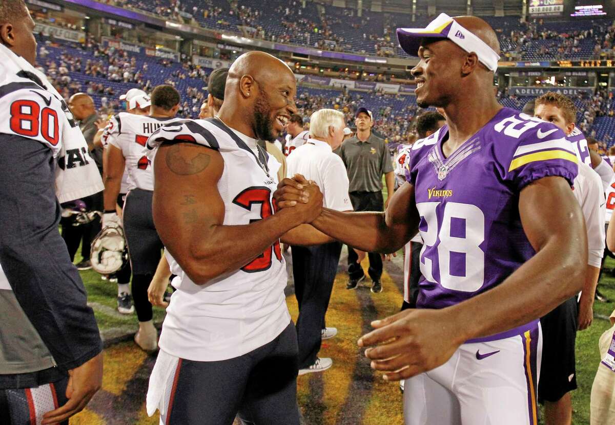 Minnesota Vikings running back Adrian Peterson (28) chats with Houston Texans free safety Danieal Manning (38) after an NFL preseason football game, Friday, Aug. 9, 2013, in Minneapolis. The Texans won 27-13. (AP Photo/Genevieve Ross)