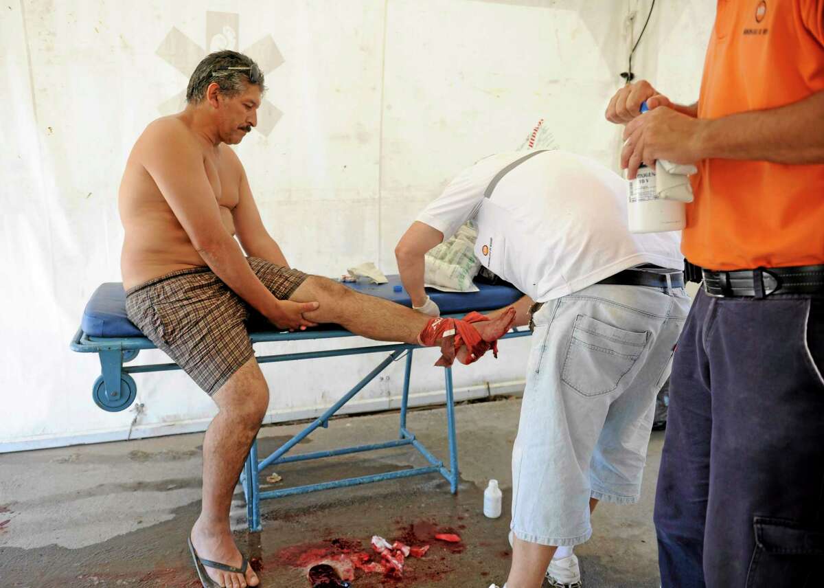 A man is treated after he was bit by a palometa, a type of piranha, while wading in the Parana River in Rosario, Argentina, Wednesday, Dec. 25, 2013. Lifeguards director Federico Cornier said Thursday that thousands of bathers were cooling off from 100 degree temperatures in the Parana River on Wednesday when bathers suddenly came to them complaining of bite marks on their hands and feet. He blamed the attack on palometas, îa type of piranha, big, voracious and with sharp teeth that can really bite.î (AP Photo/La Capital, Silvina Salinas)