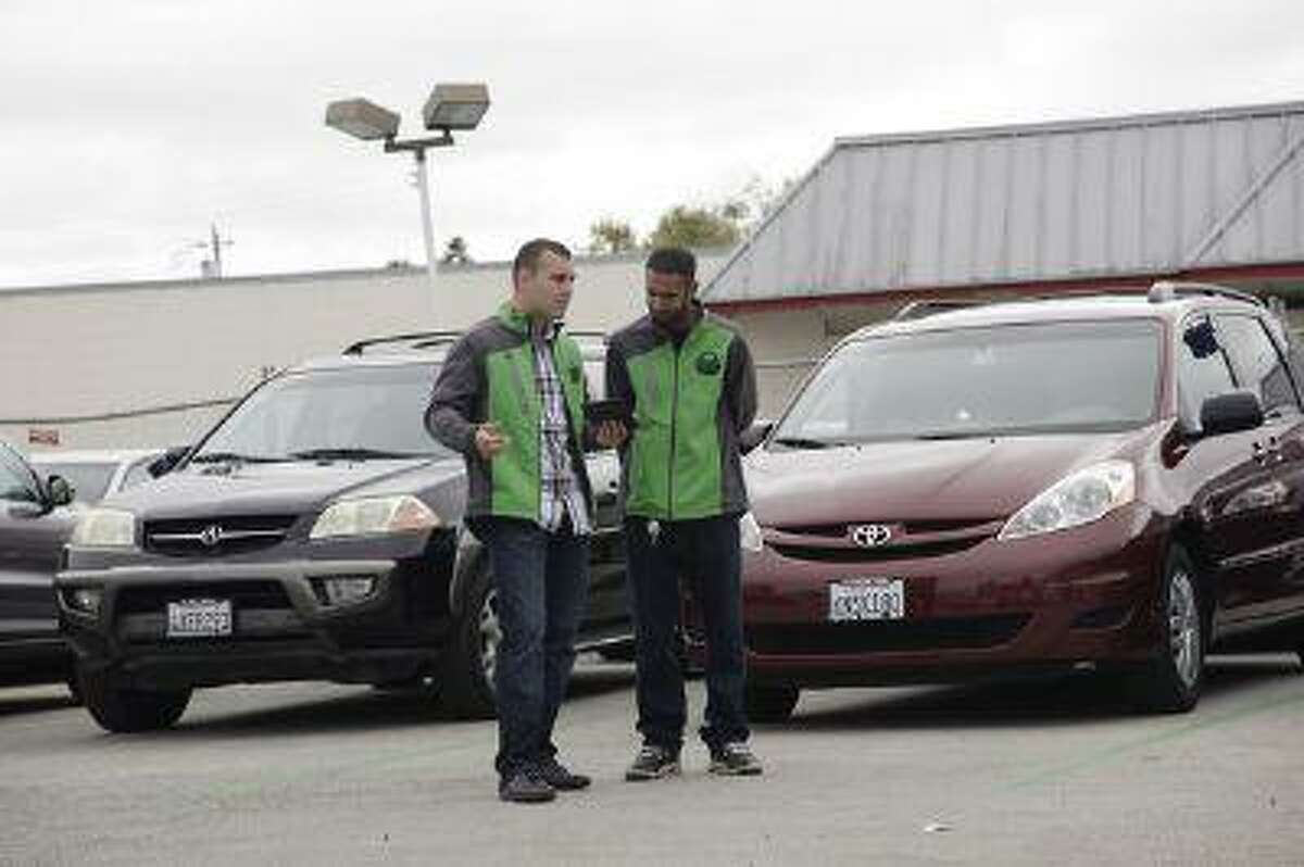 Andrei Parenco and Harun Ghori look over their inventory of available cars at FlightCar in Millbrae, Calif. on Wednesday, Aug. 7, 2013. FlightCar is a car-sharing service that allows travelers to leave their cars in a parking lot so that others can rent it while they are gone.
