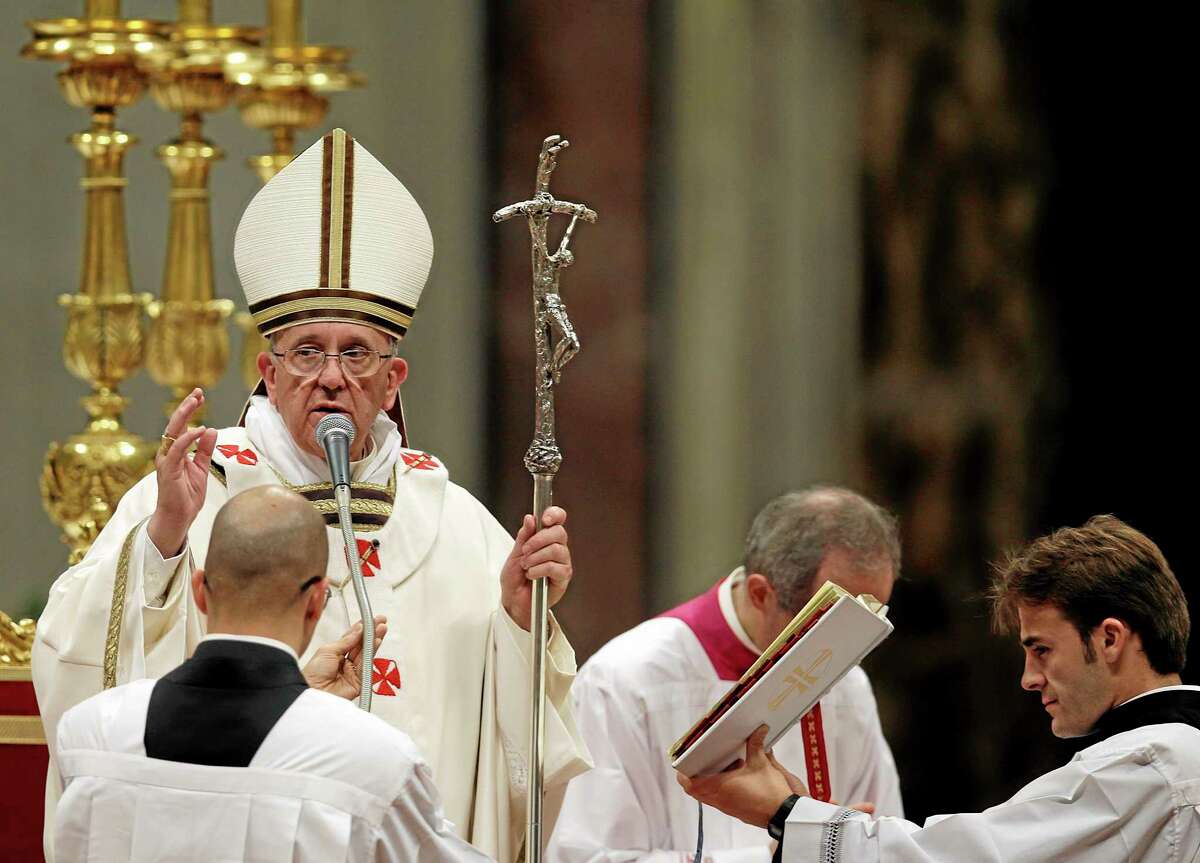 Pope Francis delivers a blessing at the end of the Christmas Eve Mass in St. Peter's Basilica at the Vatican, Tuesday, Dec. 24, 2013. (AP Photo/Gregorio Borgia)