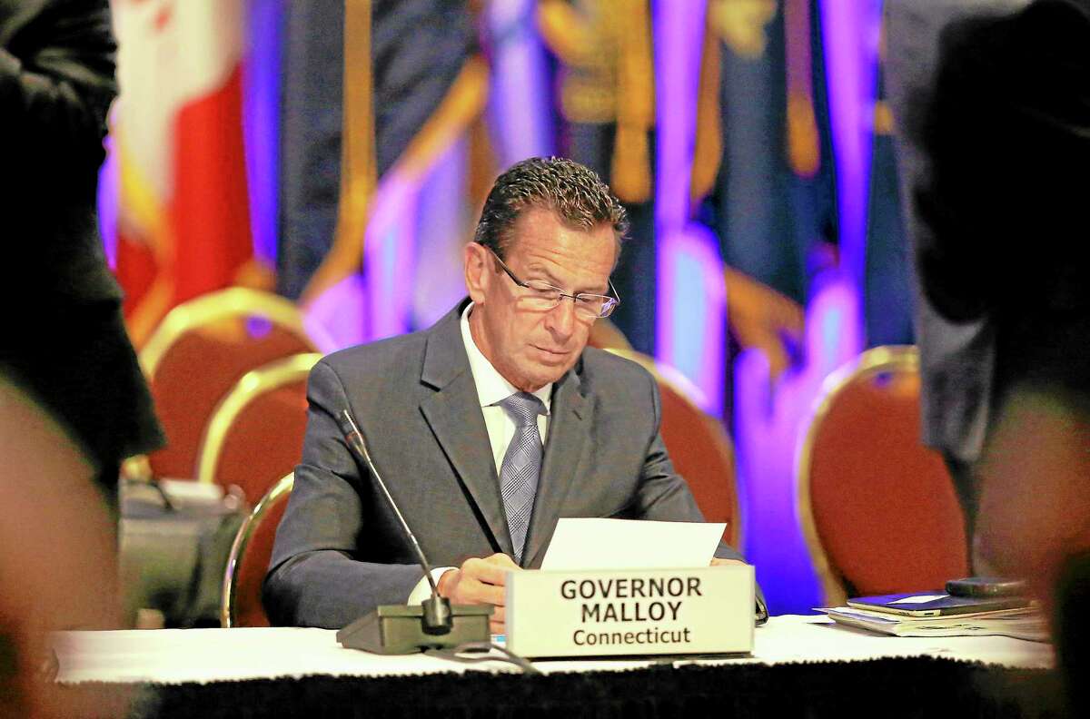Gov. Dannel Malloy looks over some notes during a session of the National Governors Association meeting Sunday, Aug. 4, 2013 in Milwaukee.