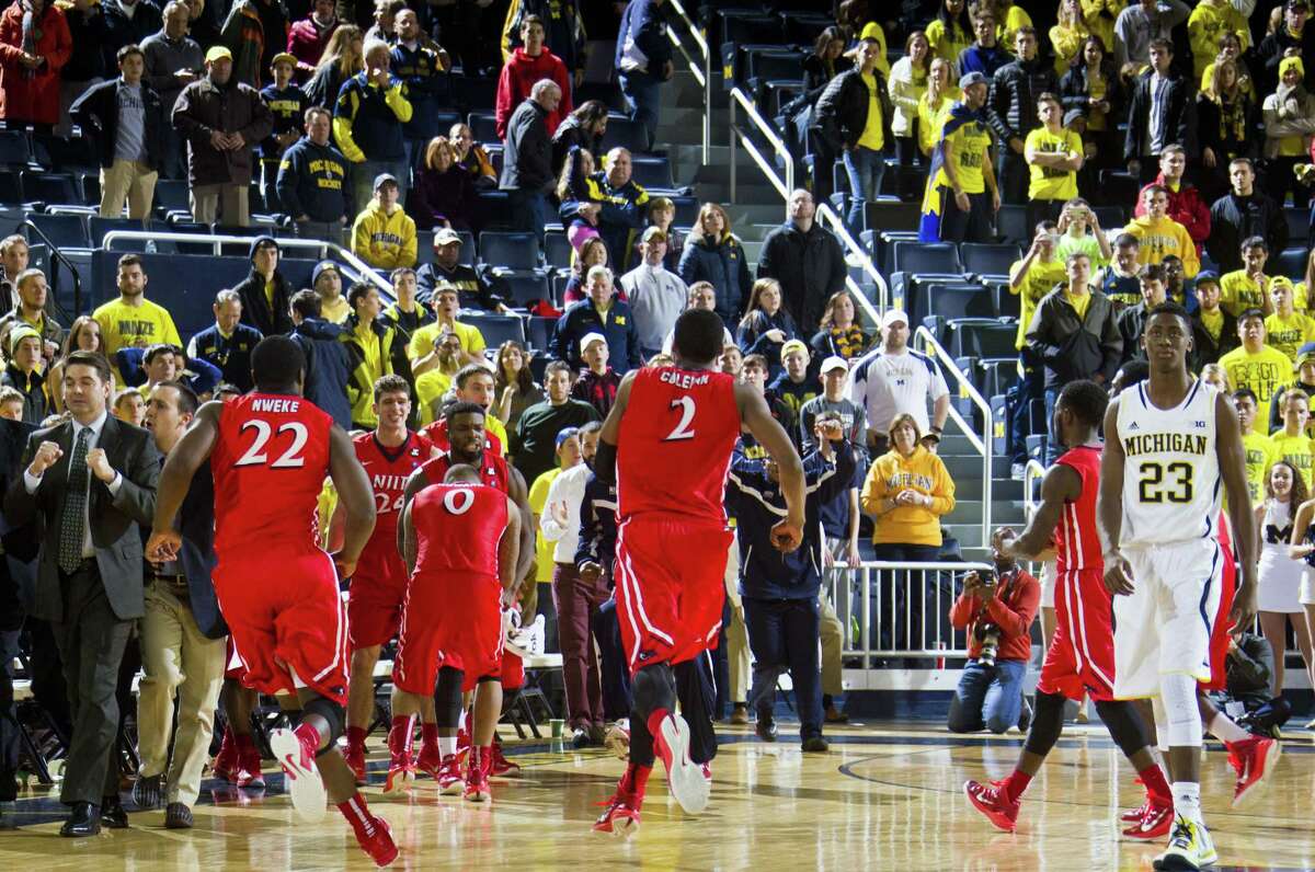 NJIT head coach Jim Engles, far left, celebrates with his players as Michigan guard Caris LeVert (23) walks off the court after Saturday’s game at Crisler Center in Ann Arbor, Mich.