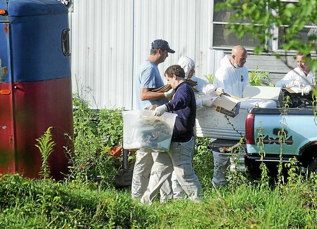 New York State Police crime scene investigators carry items from the bed of a pickup truck at the home of Stephen Howells II and Nicole F. Vaisey, in Hermon, N.Y., Sunday, Aug. 17, 2014. Vaisey and Howells were arrested Friday on charges of first-degree kidnapping with the intent to physically harm or sexually abuse two Amish sister. (AP Photo/Watertown Daily Times, Melanie Kimber Lago)
