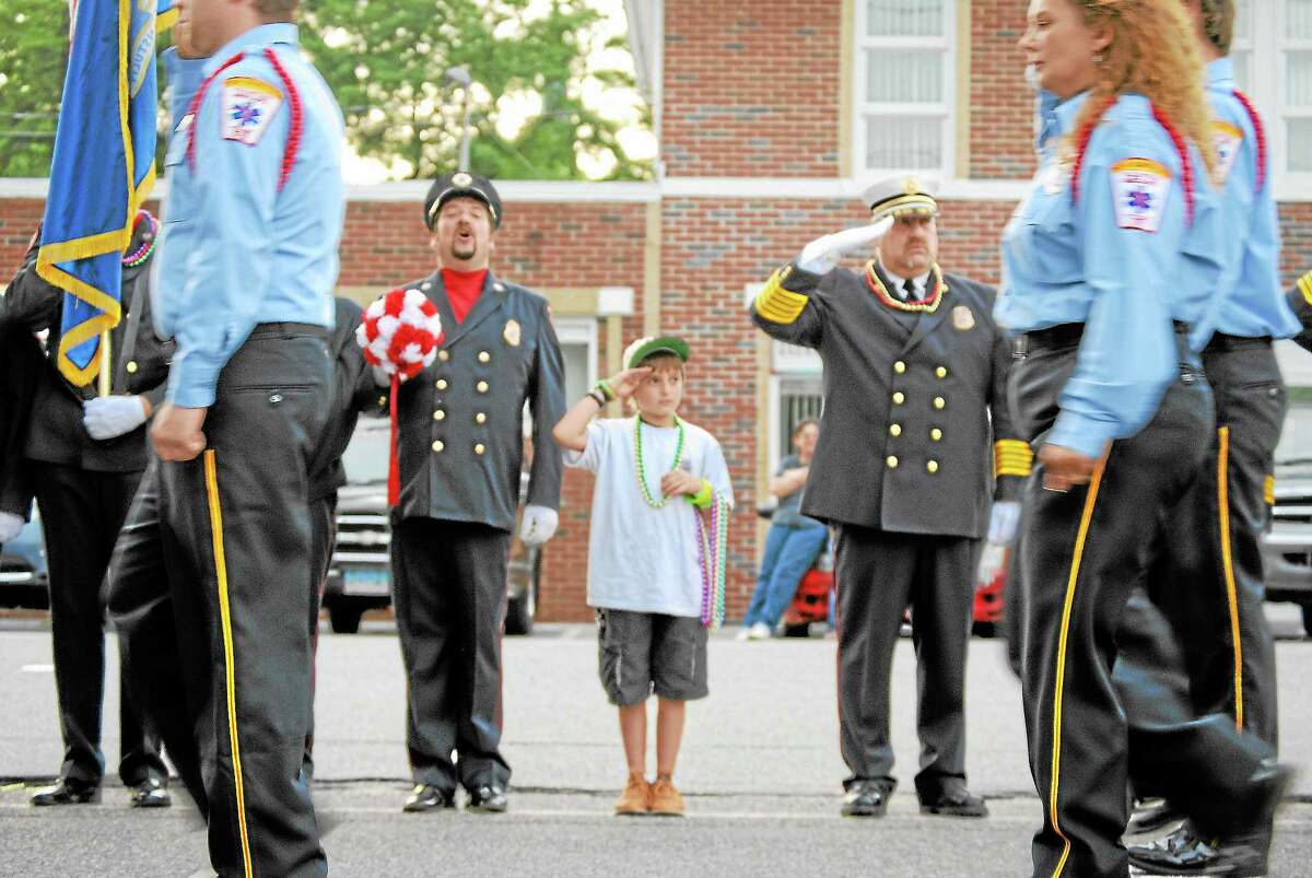 Mason Goodell salutes returning soldiers with his father, left, on Aug. 17 during the annual Winsted Fireman’s Carnival parade.