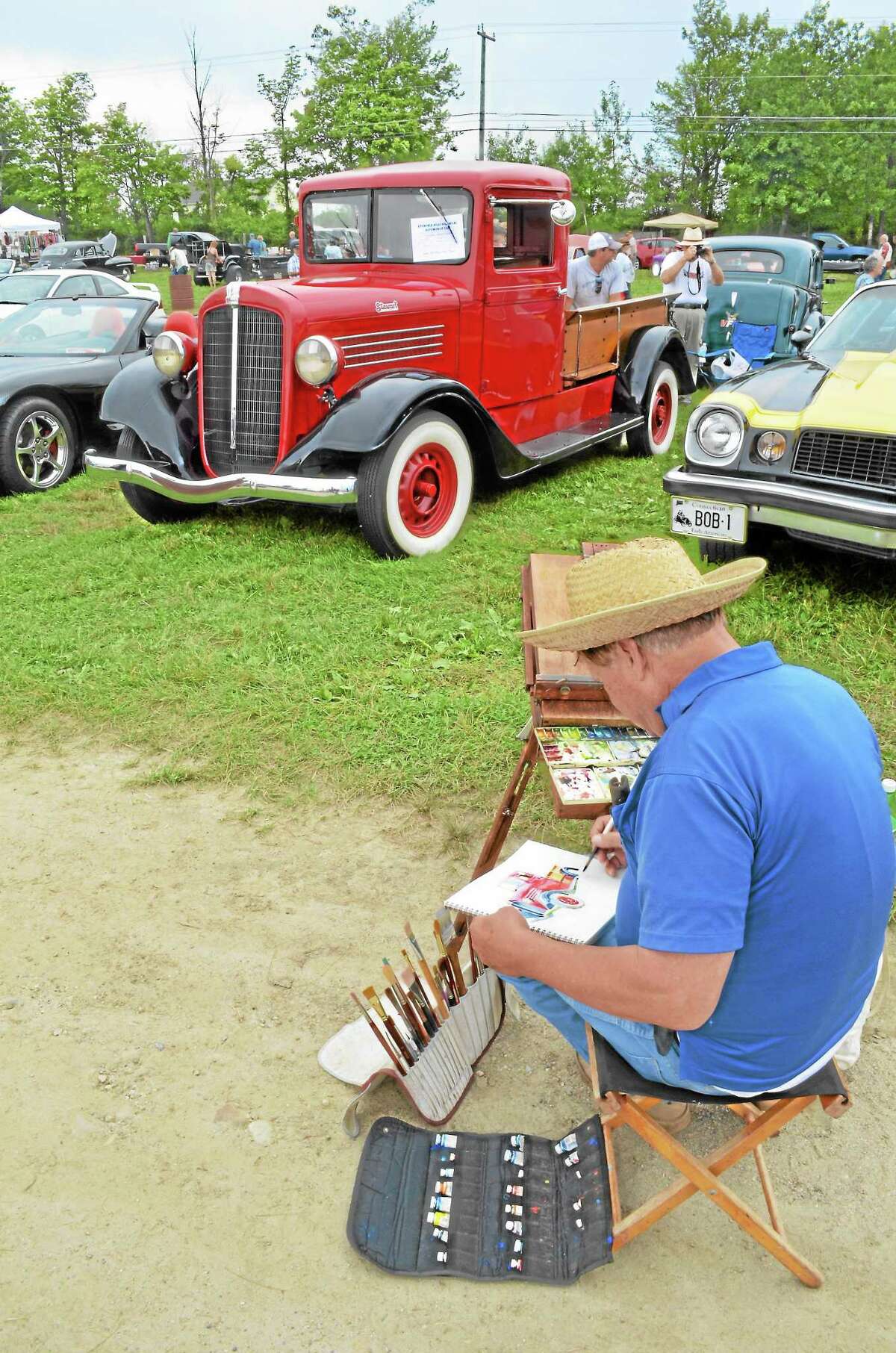 Artist Dan Nichols paints one of the many classic cars on display during the Litchfield Hills Historical Automobile Club’s 38th-annual car show and swap meet at the Goshen Fairgrounds on Sunday, Aug. 18.