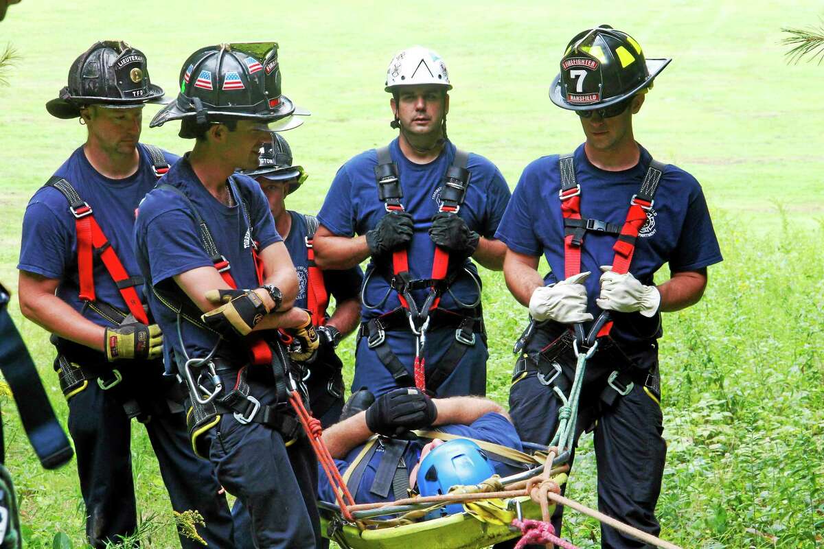 Firefighters participating in a drill carry a “victim”, Alex Battaglino, a Torrington Fire Department firefighter, up a hill at Major Besse Park on Thursday, Aug. 21, in Torrington.