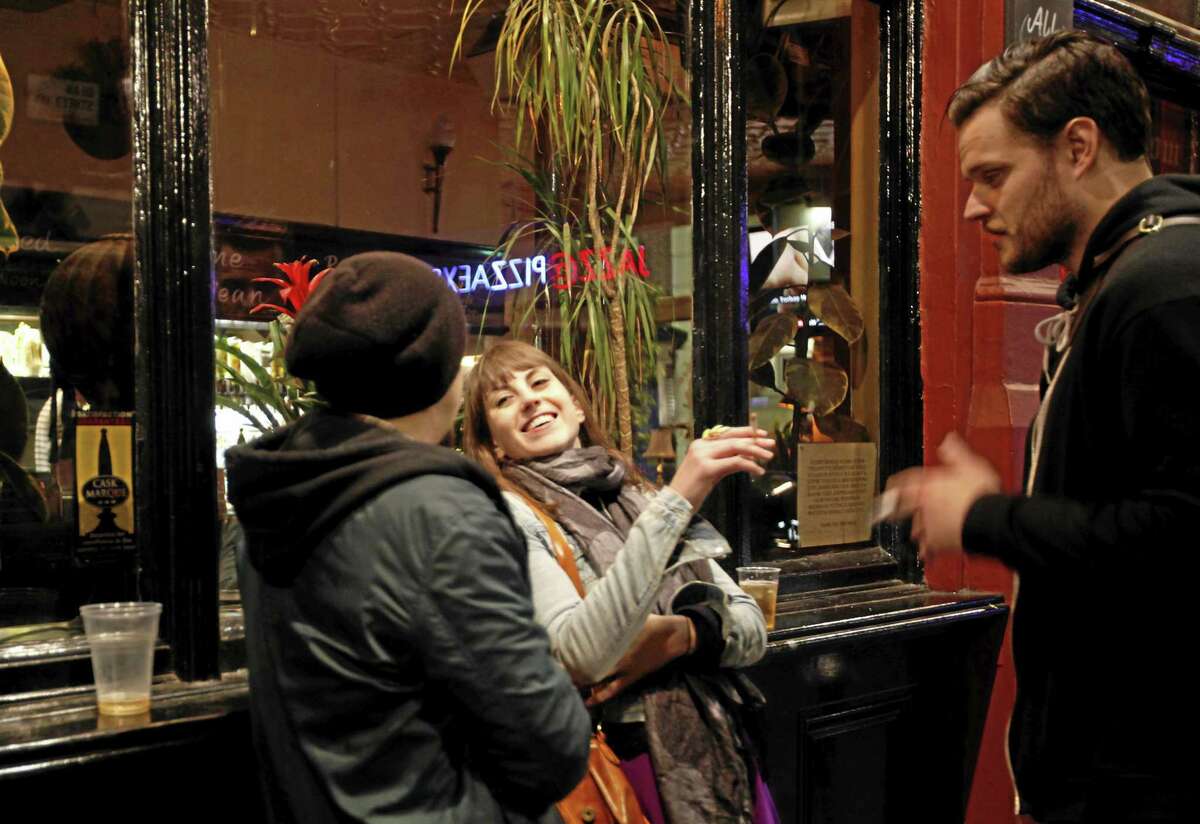 Young people enjoy a smoke as they drink outside a bar in the central London area of Soho in this 2012 file photo.