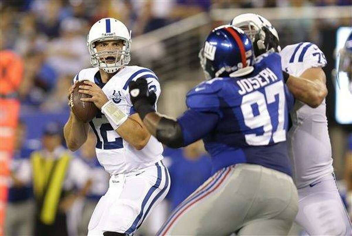 Indianapolis Colts quarterback Andrew Luck (12) looks to pas as New York Giants' Linval Joseph (97) rushes him during the first half of an NFL preseason football game Sunday, Aug. 18, 2013, in East Rutherford, N.J. (AP Photo/Kathy Willens)