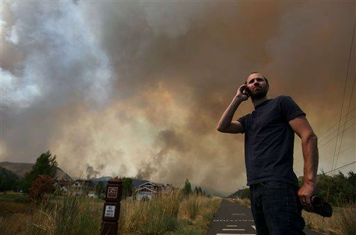 Kevin Bullock, of Bellevue, Idaho, watches smoke from the 64,000 acre Beaver Creek Fire on Friday, Aug., 16, 2013 north of Hailey, Idaho. A number of residential neighborhoods have been evacuated because of the blaze.(AP Photo/Times-News, Ashley Smith) MANDATORY CREDIT