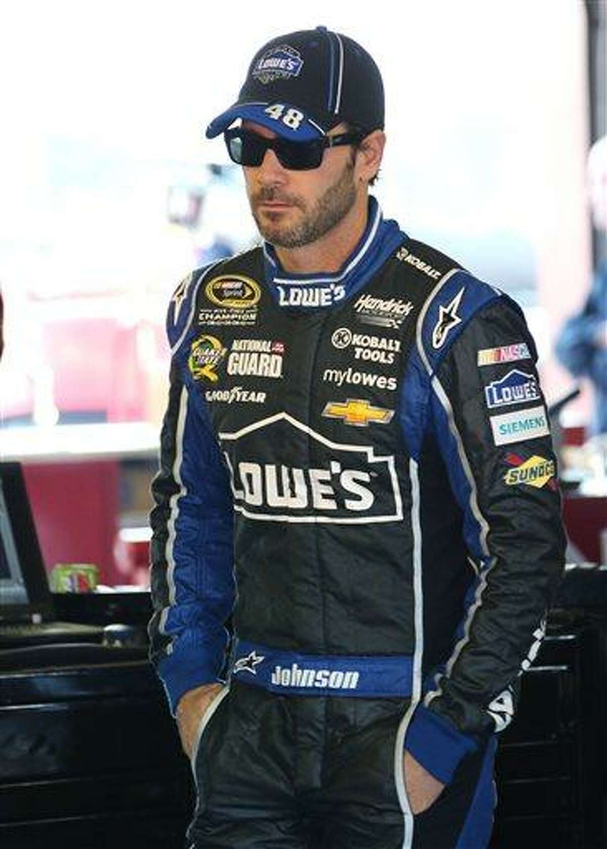 Jimmie Johnson watches as the crew works on his car during practice for the NASCAR Sprint Cup Series auto race at Michigan International Speedway in Brooklyn, Mich., Saturday, Aug. 17, 2013. (AP Photo/Bob Brodbeck)