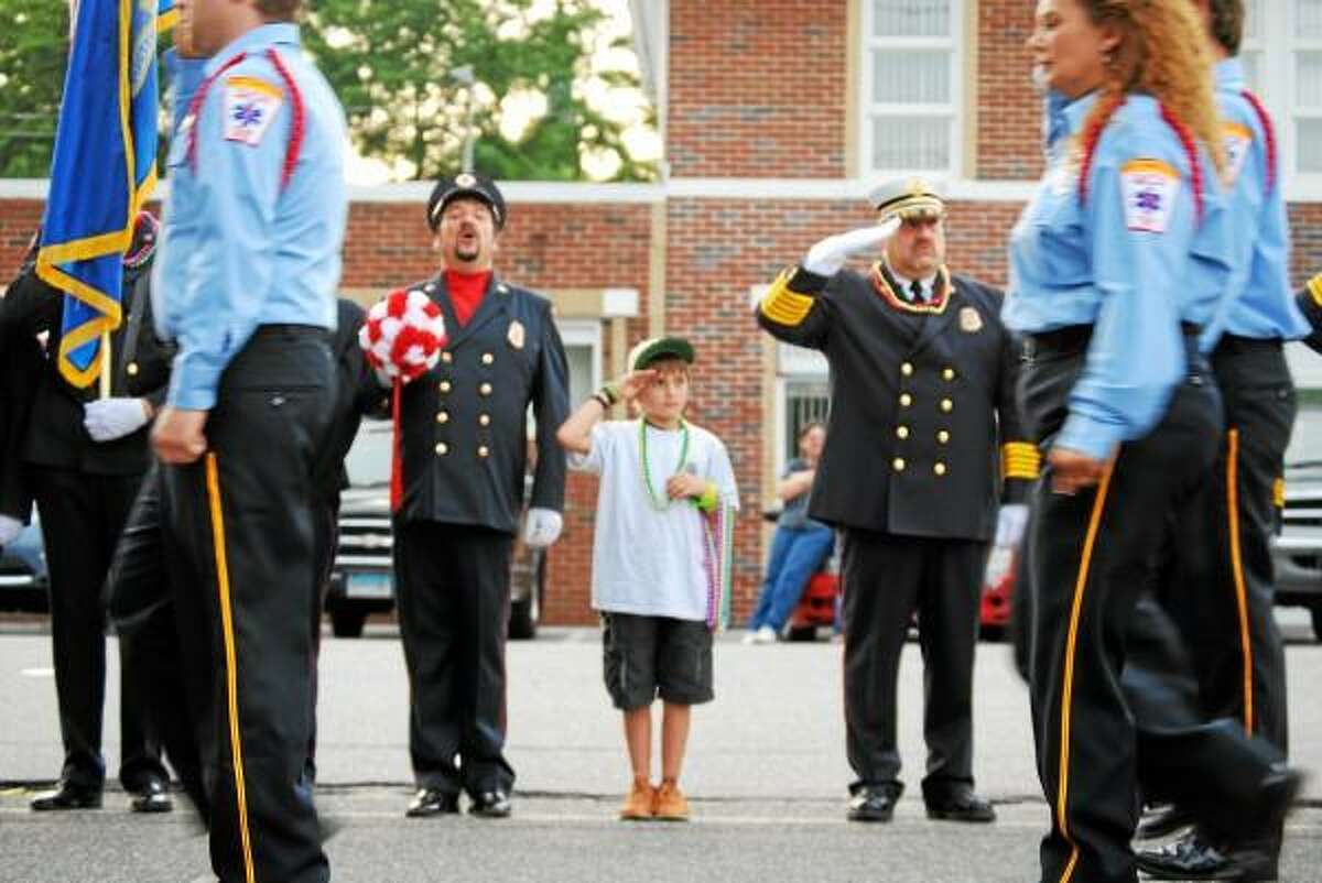 Mason Goodell salutes returning soldiers with his father, left. (Jessica Glenza-Register Citizen)