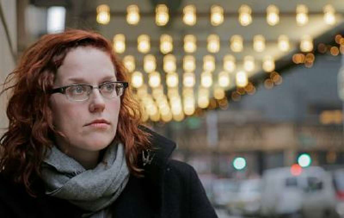 In this Dec. 3, 2013 photo, actor Adrienne Matzen poses in Chicago's theater district. Matzen, 29, who has been mostly uninsured since she turned 21, is now looking for a low monthly premium insurance plan on the federal website.
