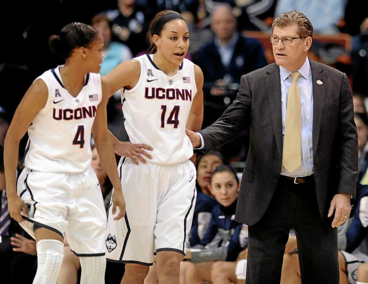 Connecticut head coach Geno Auriemma, right, speaks with Moriah Jefferson, left, and Bria Hartley, center, during the first half of an NCAA college basketball game against Rutgers in the semifinals of the American Athletic Conference women's tournament, Sunday, March 9, 2014, in Uncasville, Conn. (AP Photo/Jessica Hill)