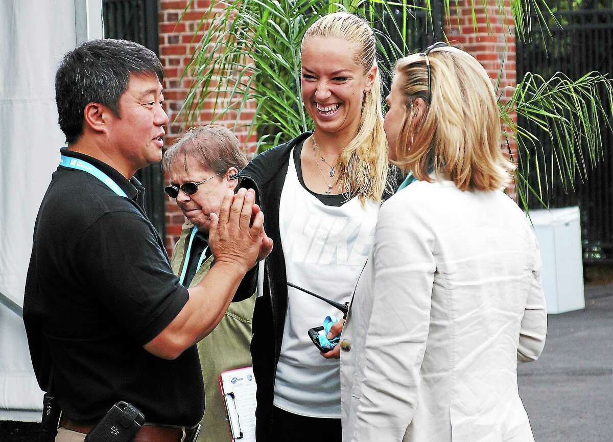 Peter Casolino — RegisterWTA Tour supervisor Tony Cho high-fives tennis pro Sabine Lisicki along with Ann Worcester before the Draw ceremony at the New Haven Open at Yale.pcasolino@newhavenregister.com