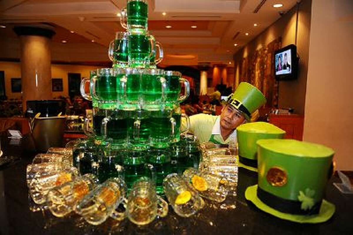 SURABAYA, INDONESIA - MARCH 14: A waitress prepares green beers during St. Patrick's Day celebrations at Sheraton Hotel on March 14, 2014 in Surabaya, Indonesia. Saint Patrick's Day is an annual religious and cultural celebration on March 17th commemorating the patron saint of Ireland. It is a public holiday in Northern Ireland, and the Republic of Ireland and is celebrated in a number of countries that have become home to the Irish diaspora. (Photo by Robertus Pudyanto/Getty Images)