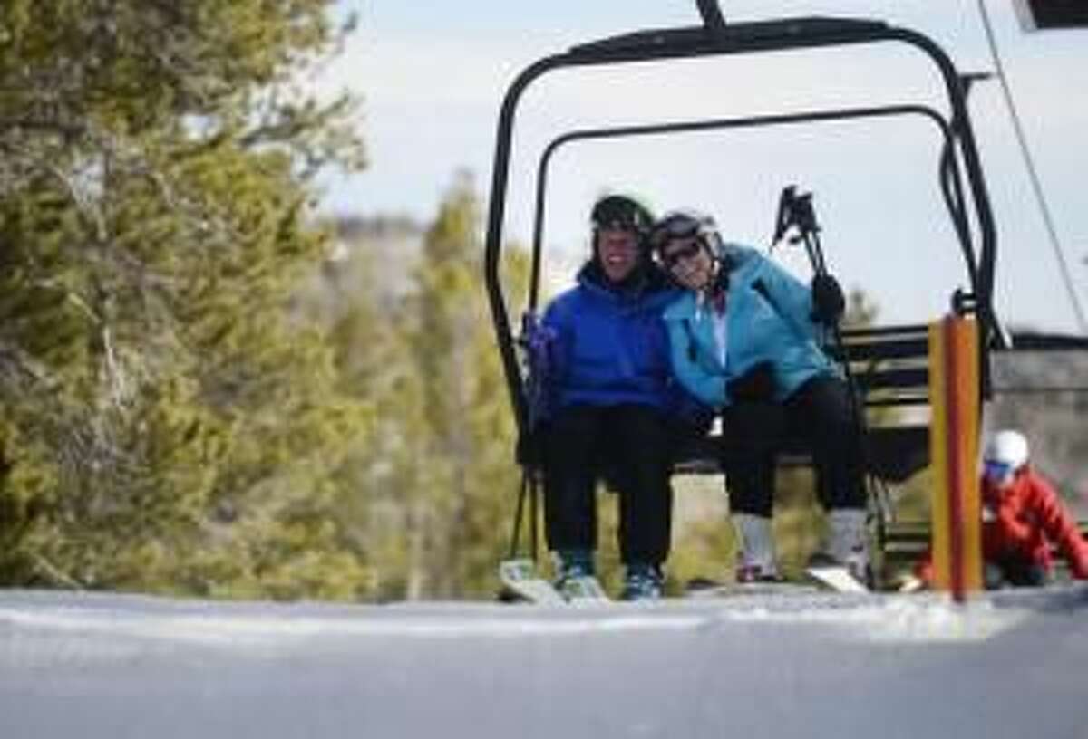 Rick Reuter, 47, left, and his wife, Traci, just moments before unloading from a lift at the Eldora Mountain Resort Wednesday morning, December 18, 2013. Rick hasn't skied for years because of Parkinson's, but has since had five brain surgeries to help control the disease enabling to now go back to what he loves-to be a ski bum.