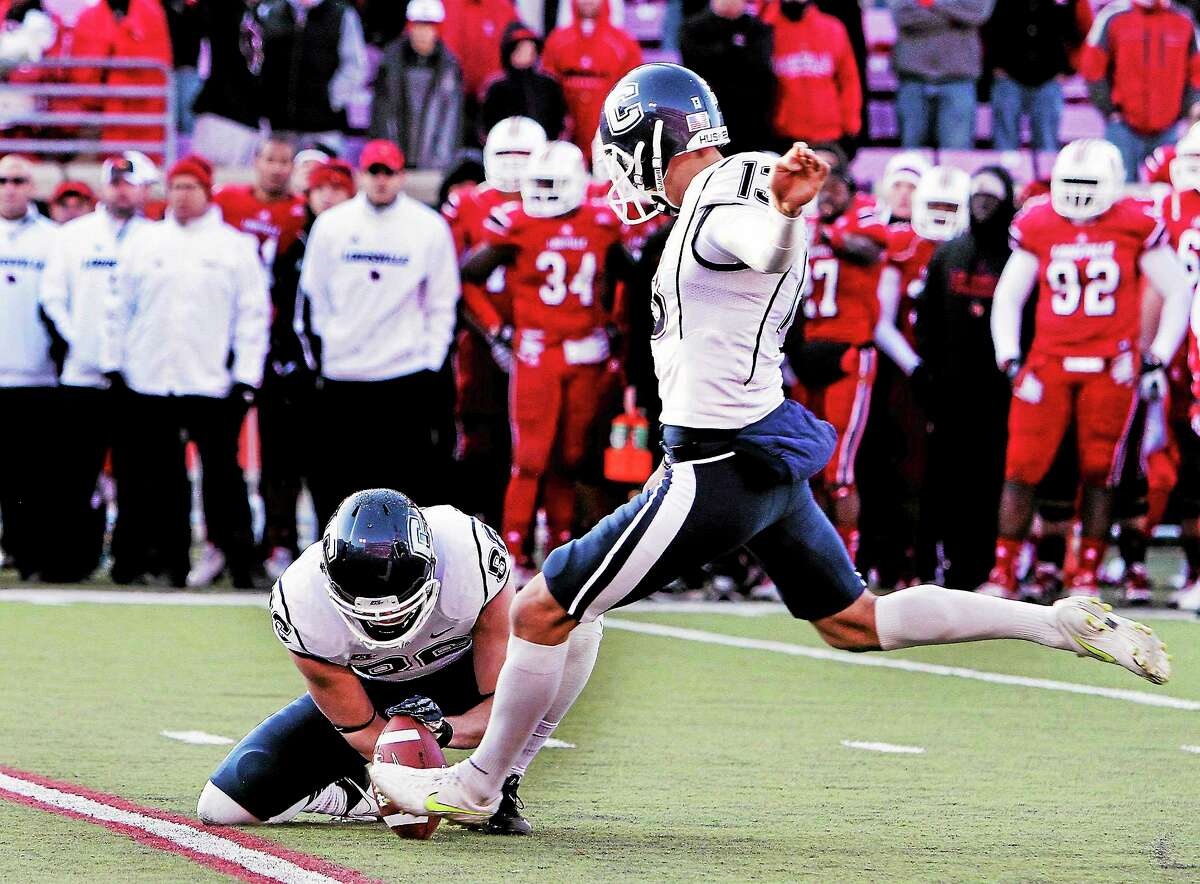 UConn kicker Chad Christen, right, kicks the game-winning 30-yard field goal in the third overtime against Louisville on Nov. 24, 2012 in Louisville, Ky. Holding is Cole Wagner. The Huskies won 23-20.