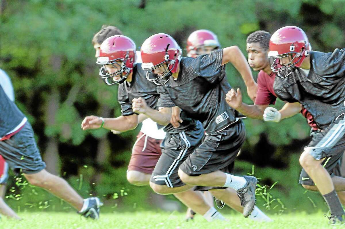 Torrington football players, sprint during drills during their first practice of the season.