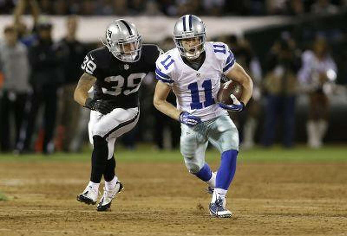 Dallas Cowboys wide receiver Cole Beasley (11) runs from Oakland Raiders defensive back Mitchell White (39) during the fourth quarter of an NFL preseason football game in Oakland, Calif., Friday, Aug. 9, 2013.