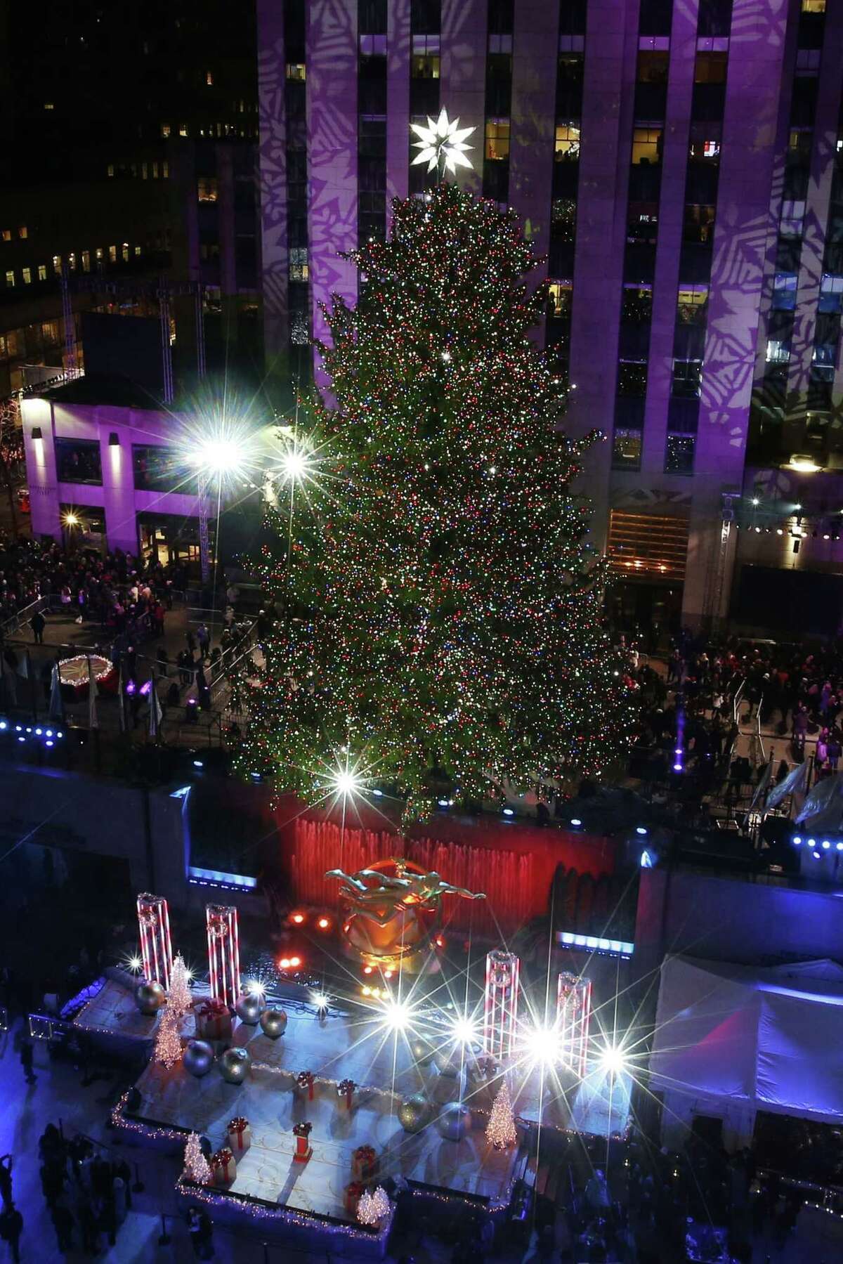 The Rockefeller Center Christmas tree is lit following a ceremony in New York on Wednesday, Dec. 3, 2014. Weighing approximately 13 tons, the 85-foot tall, 90-year-old Norway Spruce is adorned with 45,000 energy efficient LED lights. (AP Photo/Jason DeCrow)