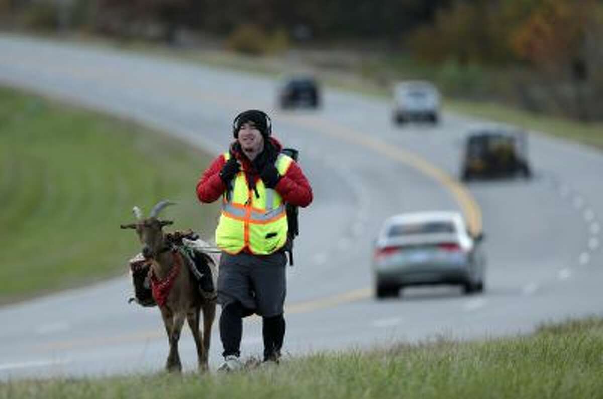 In this Wednesday, Nov. 6, 2013 photo, Steven Wescott walks with his goat, LeeRoy Brown, along a street in Lenexa, Kan.