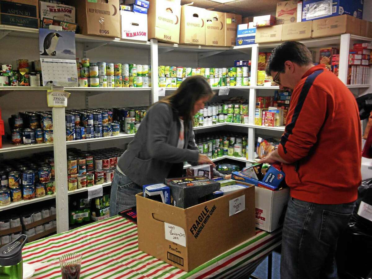 Volunteers at Friendly Hands Food Bank organize food and gifts for distribution in Torrington