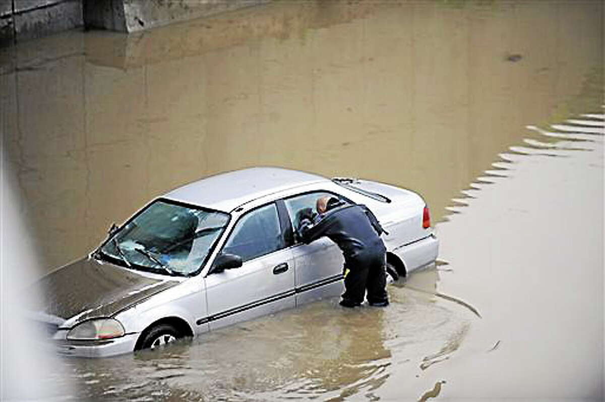 A police diver checks a flooded vehicle for any occupants along a flooded stretch of I-696 at the Warren, Mich. city limits Tuesday morning, Aug. 12, 2014. Warren Mayor James Fouts said roughly 1,000 vehicles had been abandoned in floodwaters in the suburb where many roads were closed after 5.2 inches of rain fell Monday. (AP Photo/Detroit News, David Coates) DETROIT FREE PRESS OUT; HUFFINGTON POST OUT