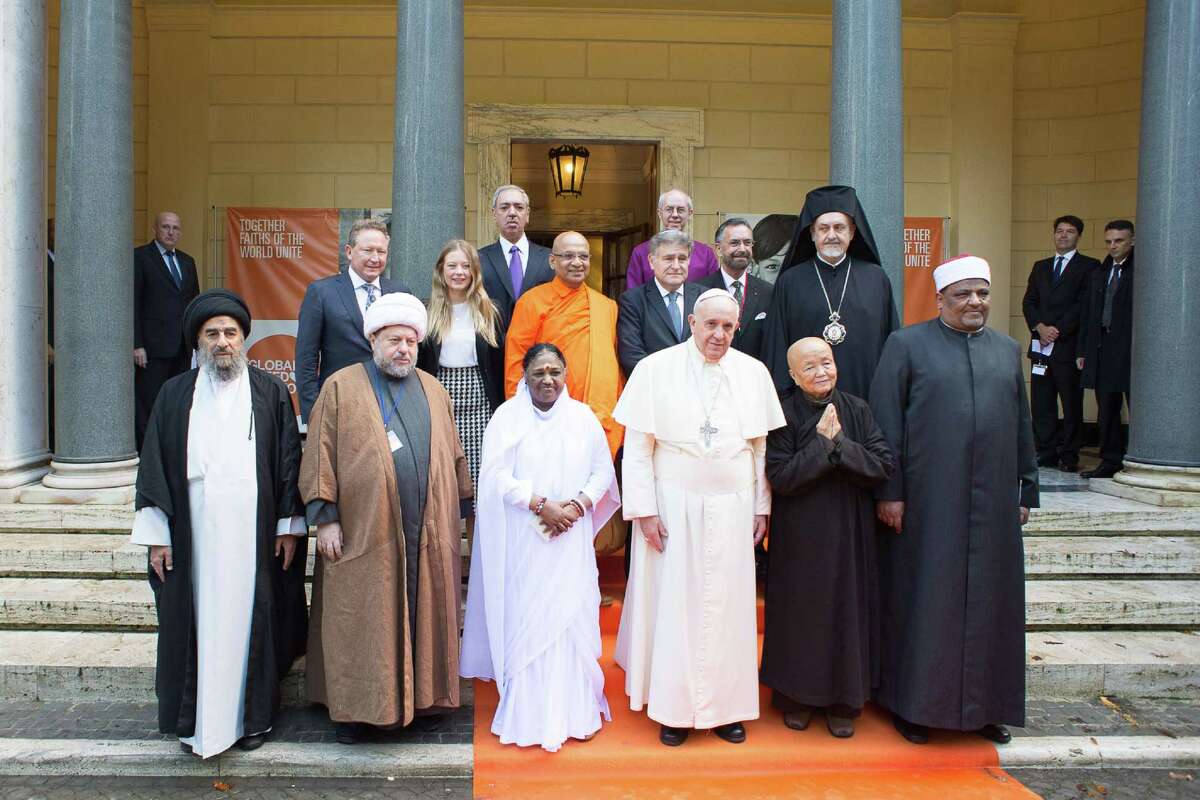 In this photo provided by Vatican newspaper L'Osservatore Romano, Pope Francis, front row, third right, poses with religious leaders on the occasion of the signing of a joint Declaration of Religious Leaders against Modern Slavery, at the Vatican, Tuesday, Dec. 2, 2014. Religious leaders from a half-dozen faiths have signed on to a new Vatican initiative to end modern-day slavery by 2020, declaring that human trafficking, forced labor and prostitution are crimes against humanity. (AP Photo/L'Osservatore Romano, ho)