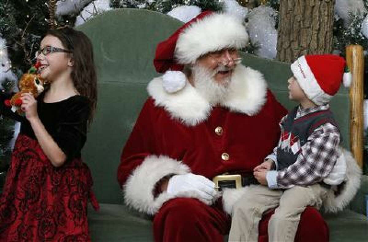 Santa chats with Asher Powell, age 6, while Asher's sister Alexis smiles Wednesday during a visit to Santa's Wonderland House inside Flatirons Crossing Mall in Broomfield, Colo.