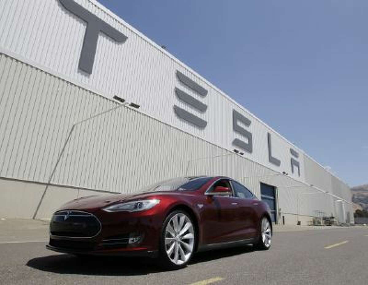 This June 22, 2012 photo shows a Tesla Model S driving outside the Tesla factory in Fremont, Calif.