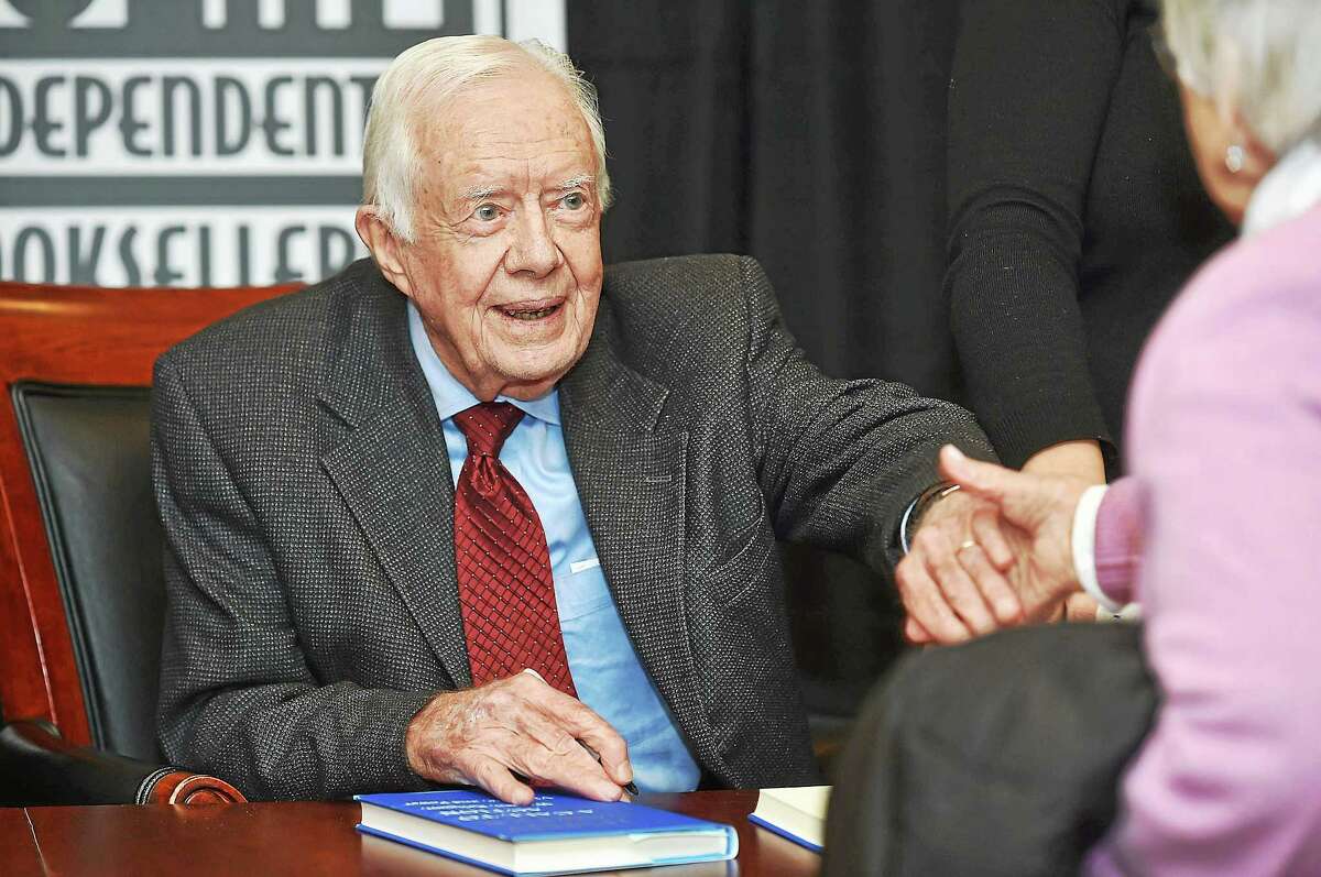 Jimmy Carter, 39th president of the United States, shakes hands before signing a copy of his book, “A Call to Action: Women, Religion, Violence and Power,” at the New Haven Lawn Club Tuesday in New Haven.