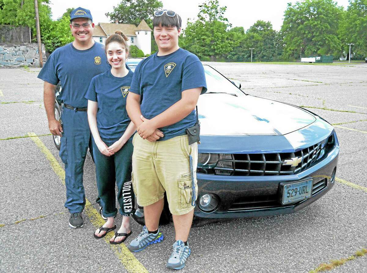 From left: Officer Steven Cloutier, Caitlin Cloutier and Chris Beyus stand in front of Steve Cloutier’s 2011 Chevy Camaro on Wednesday, August 14. All three serve in the Torrington Police Explorer’s program, which is hosting a car show on Friday on Main Street.