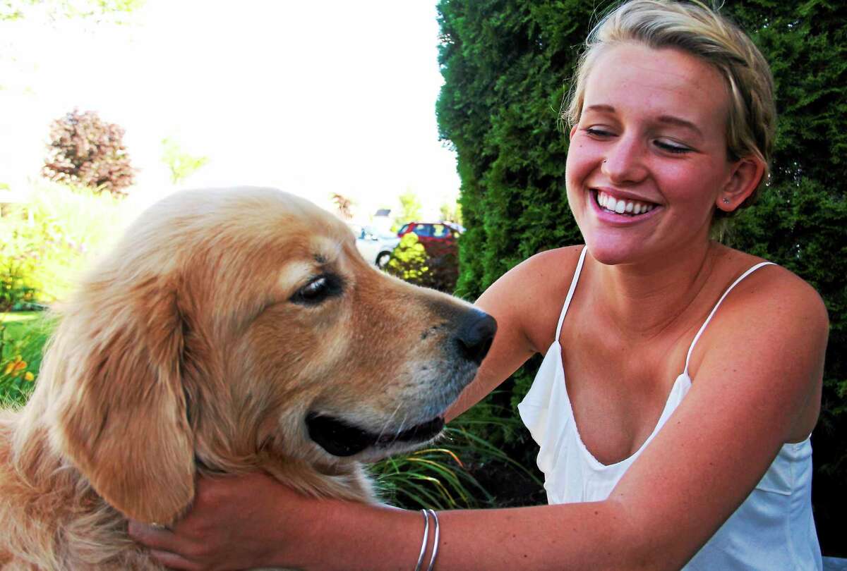 Emmy Fedor, 17, smiles as she pets her dog, Cooper Thursday in Torrington. Fedor is an intern at City Hall and is helping develop an ordinance that outlines fees for the regional animal control facility.