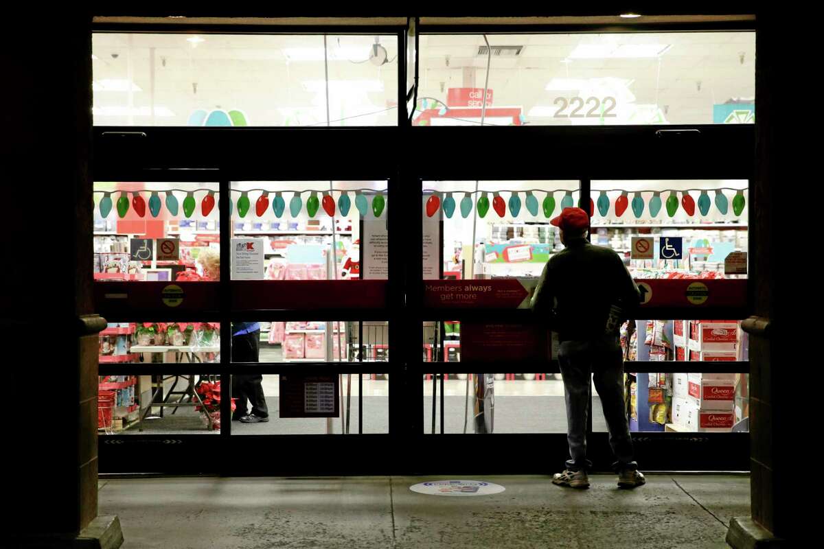 A shopper waits outside a Kmart store for it to open in Anaheim, Calif.