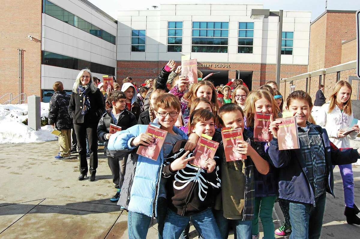 Fourth-grade student from Hinsdale School hold up their new books Friday that were dispersed as part of a town effort to increase literacy.