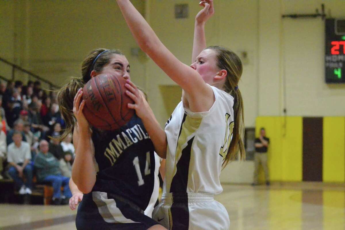 Thomaston’s Gabby Hurlbert plays tough defense on Immaculate’s Taylor Guth in the Golden Bears 55-49 win.
