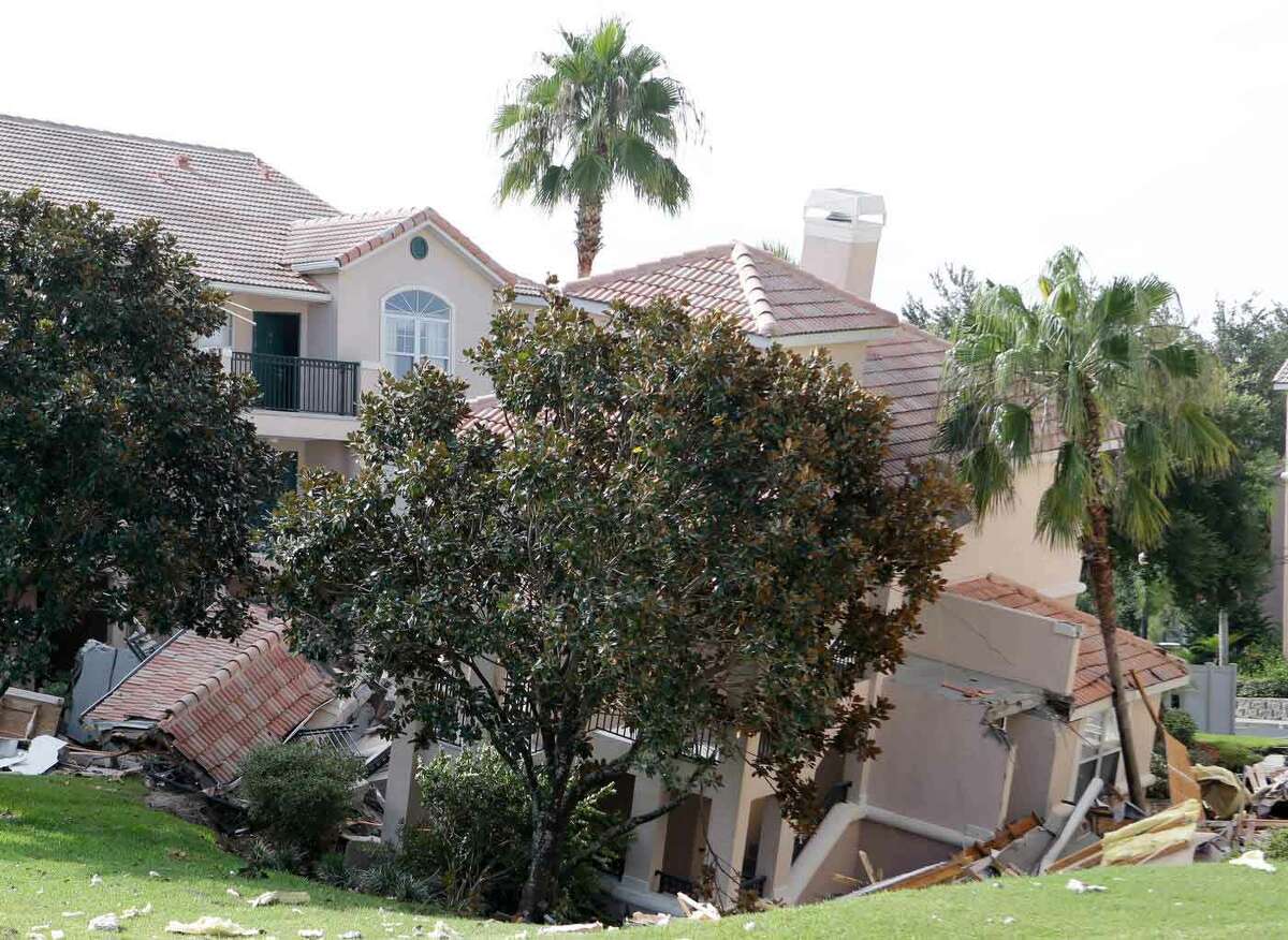A portion of a building rests in a sinkhole Monday, Aug. 12, 2013 in Clermont, Fla. The sinkhole, 40 to 50 feet in diameter, opened up overnight and damaged three buildings at the Summer Bay Resort. (AP Photo/John Raoux)