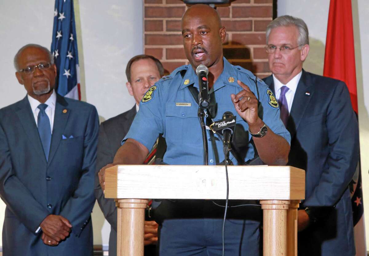 Capt. Ronald Johnson, foreground, commander of Missouri Highway Patrol's Troop C, addresses media at the University of Missouri St. Louis on Thursday, Aug. 14, 2014, at after Missouri Gov. Jay Nixon, right, announced that Johnson and the Highway Patrol will be taking over security at the Ferguson protest scene. St. Louis County Executive Charlie Dooley, left, and St. Louis Mayor Francis Slay also made statements. (AP Photo/St. Louis Post-Dispatch, Christian Gooden)