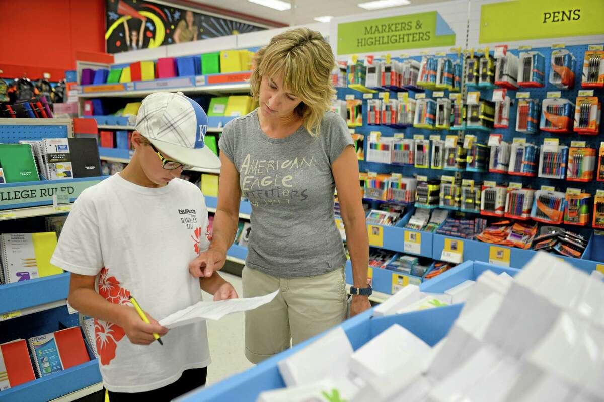In this July 30 photo, Jill Courtney, right, shops for school supplies for her sons, Will, left, and Reid, not seen, at a Target store in St. Joseph, Missouri.