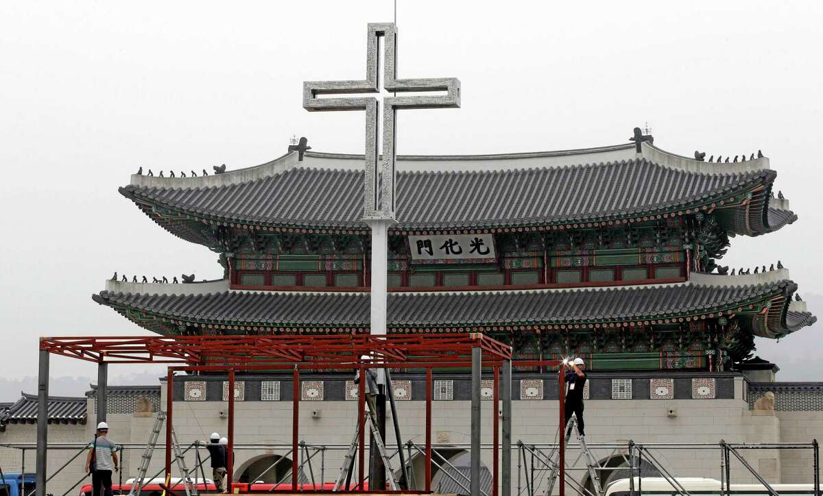 Workers set up a platform in prepare for a special holy mass by Pope Francis in front of the Gwanghwamun, the main gate of the 14th-century Gyeongbok Palace, in Seoul, South Korea, Wednesday, Aug. 13, 2014. Pope Francis is scheduled to make a five-day trip to South Korea, starting Aug. 14 to participate in a Catholic youth festival and to preside over a beatification ceremony for 124 Korean martyrs. (AP Photo/Lee Jin-man)