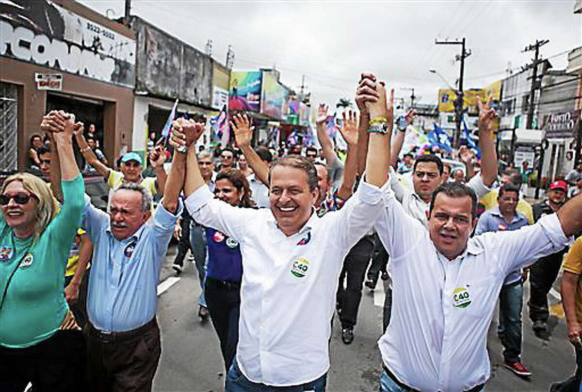 In this Aug. 8, 2014 photo released by the Partido Socialista Brasilero, PSB, Brazilian presidential candidate Eduardo Campos, center, campaigns in Arapiraca, Brazil. The PSB presidential candidate died Wednesday, Aug. 13, 2014, when the small plane that was carrying him and several campaign officials plunged into a residential neighborhood in the port city of Santos, a City Hall official there said. (AP Photo/Partido Socialista Brasilero, Alexandre Severo)