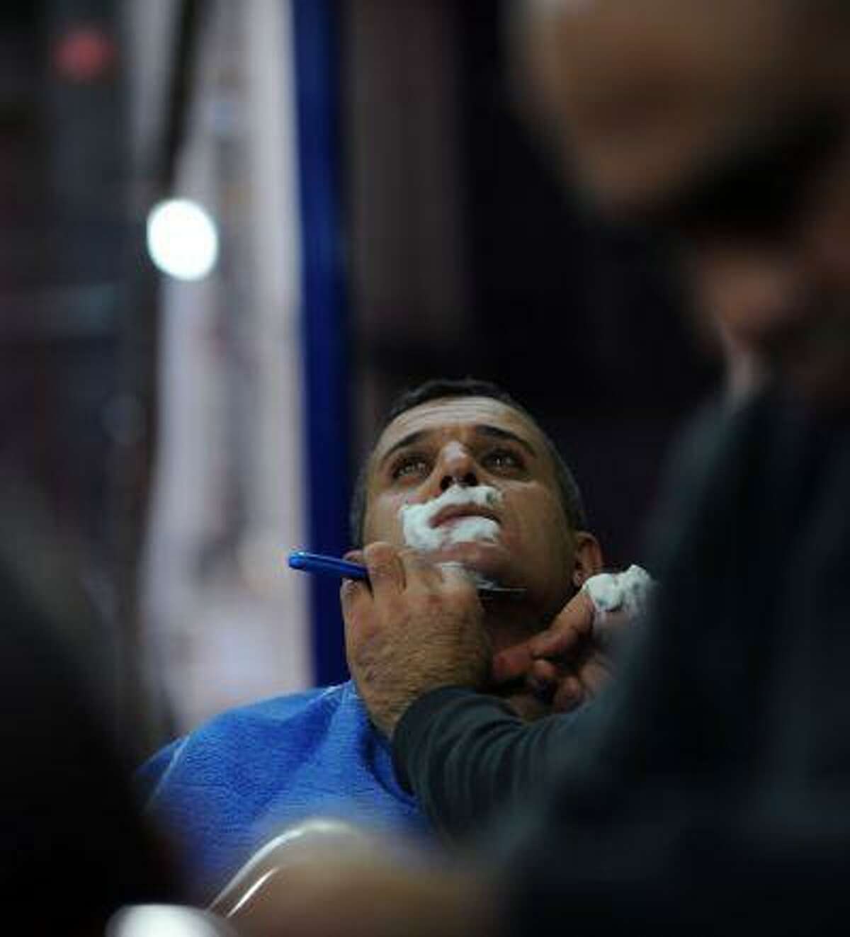 A barber shaves a man on January 25, 2013, in Istanbul. Already known the world over for its baths, coffee and sweet Turkish delights, Turkey is on the road to adding another item to its roster of specialities: the moustache. (AFP PHOTO/BULENT KILIC)