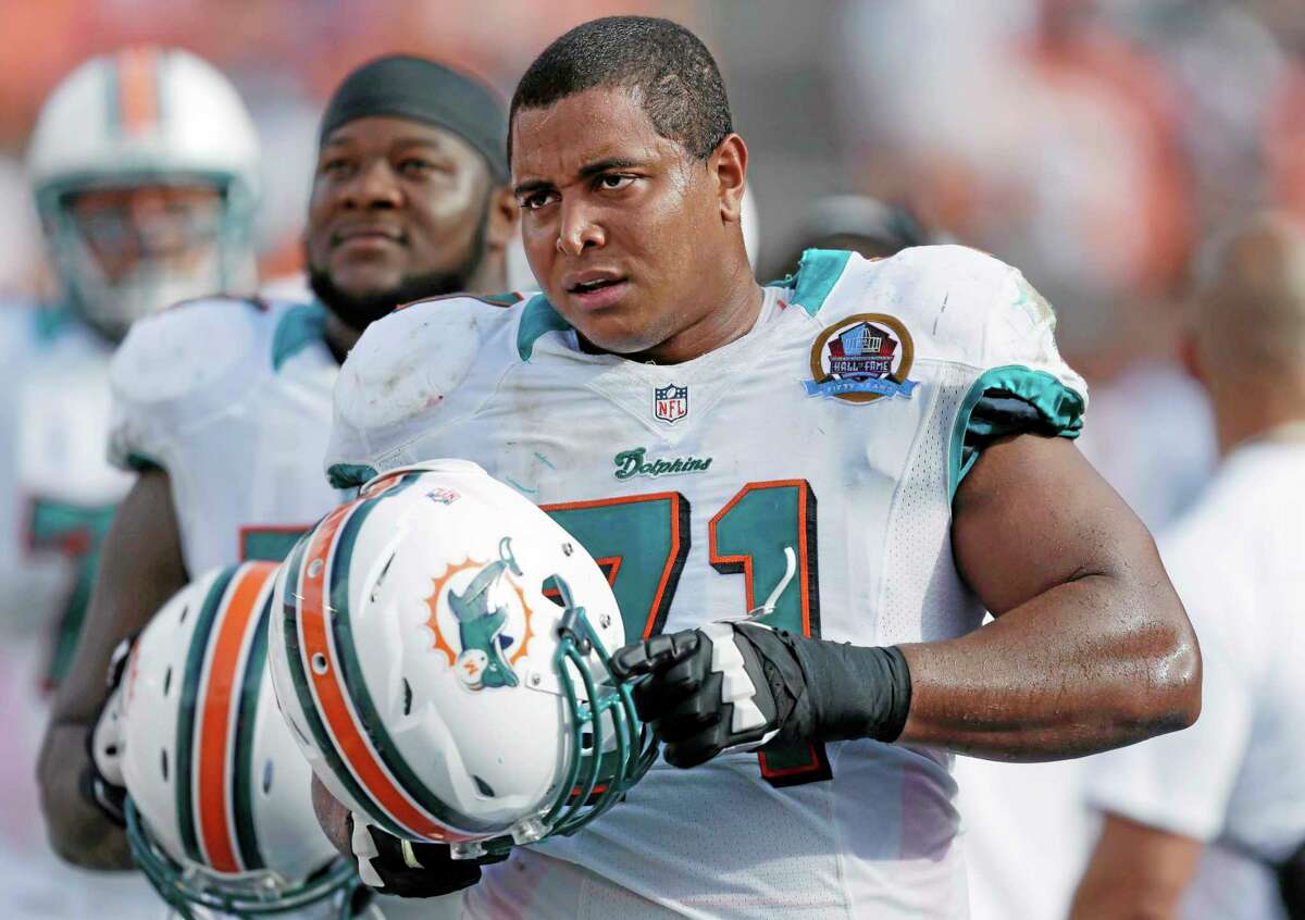 In this Dec. 16, 2012, photo, Miami Dolphins tackle Jonathan Martin (71) stands on the sidelines during the Dolphins’ NFL football game against the Jacksonville Jaguars in Miami. Martin, the offensive tackle at the center of the Dolphins’ bullying scandal, has been traded to the San Francisco 49ers. The Dolphins announced the deal Tuesday night, March 11, 2014, on the first day of NFL free agency. Martin’s move cross country brings him back to the Bay Area to be reunited with his former Stanford coach, Jim Harbaugh.